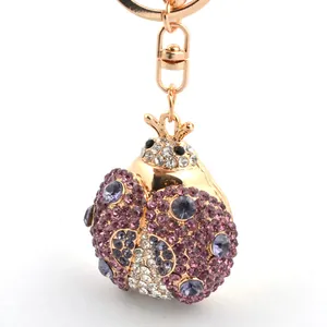 Porte-clés coccinelle étincelant avec cristaux violets et blancs sur métal doré