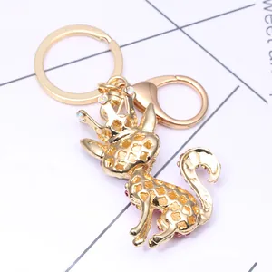 Detail of a golden cat keychain with hollow design and colorful rhinestones