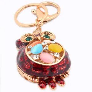 Golden owl keychain with colorful enamel and sparkling rhinestones on a white background
