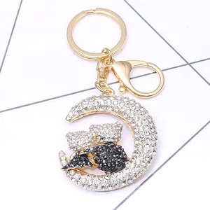 Close-up of crescent moon keychain with rhinestones and black and white bears