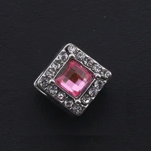 Détail d'une perle carrée rose sertie de zircons blancs sur monture en métal argenté