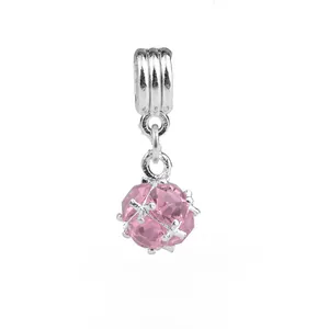 Vue macro d'une breloque en cristal rose facetté avec cadre en maille argentée pour bijoux