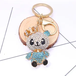 Cute panda keychain with sparkling blue and white rhinestones on a rustic wood slice