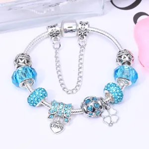 Silbernes Charm-Armband mit blauen Kristallperlen, Schleifenanhänger und Kleeblatt
