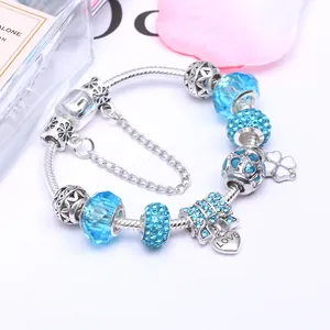 Silbernes Schlangen-Charm-Armband mit blauen Glasperlen und glitzerndem Schleifenanhänger