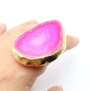 Detalle macro de anillo de rebanada de ágata fucsia natural con baño de oro pulido