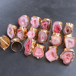 Dettaglio di anelli placcati oro con pietre di agata naturale irregolari e druzy colorate