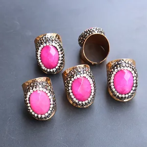 Detail view of oval rose red agate rings with rhinestone halo and adjustable gold band
