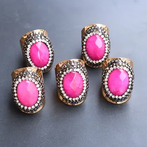 Detailed macro view of 5-piece pink agate rings with gold hammered finish and side pavé crystals