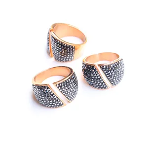 Makro-Detail von Roségold-Ringen mit Holzkohle-Zirkon-Pavé und geometrischen Lücken