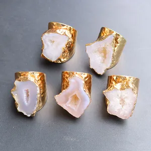 Dettaglio macro di fette di agata geode naturale su anelli in ottone placcato oro
