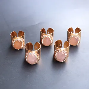Detalle de un set de cinco anillos dorados con piedras rosas facetadas y pequeños brillantes