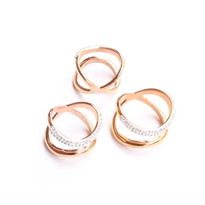 Anillos cruzados de oro rosa con pavé de circonitas brillantes sobre fondo blanco