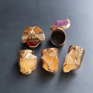Detail of five gold plated rings with raw natural amethyst and citrine crystals