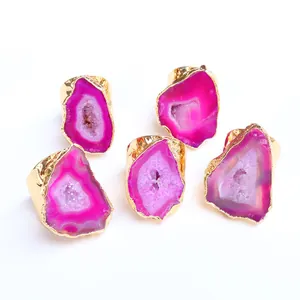 Dettaglio di anelli in agata naturale rosa con forme irregolari e bordi in ottone dorato