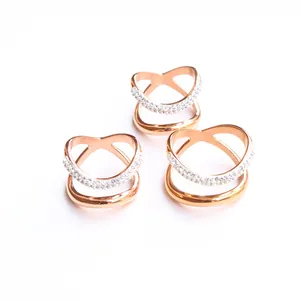 Primer plano de anillos dobles de oro rosa con cristales pavimentados y diseño cruzado