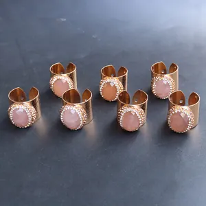Detalle de un set de 7 anillos dorados con piedras rosas y circonitas blancas top