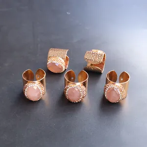 Set de 5 anillos dorados martillados con piedra rosa facetada y borde de pedrería fina