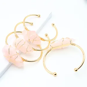 Set van vier gouden armbanden met ruwe roze kwartsstenen en handgemaakte draadwikkeling