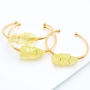 Detail van handgewikkelde ruwe gele citriensteen op een gouden open armband