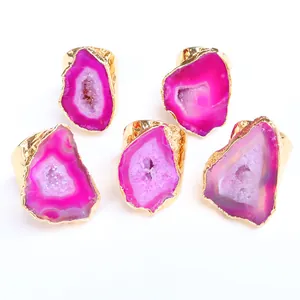 Dettaglio di cinque anelli irregolari in geode di agata fucsia con bordi placcati oro