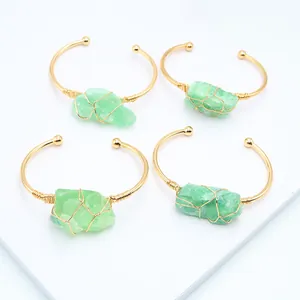 Detail van handgemaakte goudkleurige armbanden met ruwe groene fluoriet edelstenen