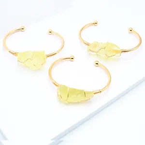 Macrodetail van de omwikkelde gele citrienstenen op gouden verstelbare armbanden