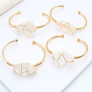 Dettaglio di quattro bracciali fatti a mano in filo dorato con cristalli bianchi naturali