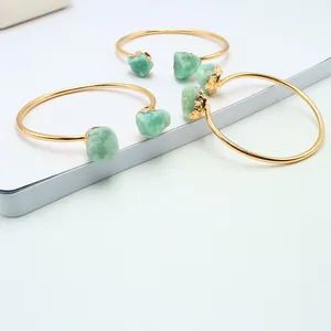 Dettaglio del bracciale aperto dorato con pietre di avventurina verde grezza