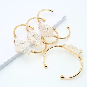 Bracciale rigido in cristallo bianco naturale avvolto in filo dorato con design a C