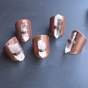 Close-up of handmade copper rings with raw white crystal pillars and wire-wrapped detail