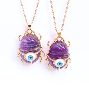 Gold-plated beetle necklace with purple amethyst stone and blue evil eye detail