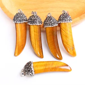 Detailed view of tiger eye horn pendants with sparkling rhinestone inlay and silver bails