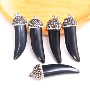 Detail of horn pendants with polished black stones and glittering rhinestone accents