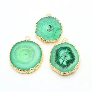 Three natural green agate slice pendants with gold plated edges on white background