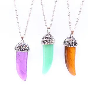 Three crystal horn pendants in purple, green, and tiger eye with sparkling diamond accents