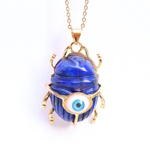 Close-up of lapis lazuli scarab beetle pendant with evil eye in gold plating