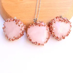 Nahaufnahme von Rosenquarz-Herzanhängern mit Roségold-Rand und feiner Silberhalskette