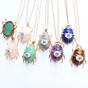 Detail view of multicolored scarab necklaces with crystal textures and golden chains