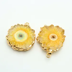 Macro shot of natural crystal sunflower pendant with golden plating and agate slice detail