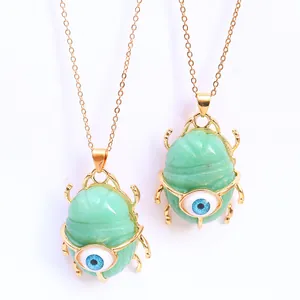 Natural green stone scarab beetle pendant necklace with blue evil eye detail in gold