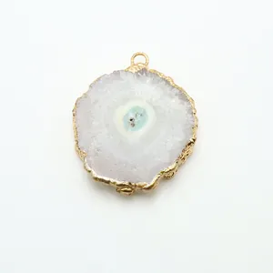 Macro view of crystal cluster pendant with gold-plated edge and natural quartz texture