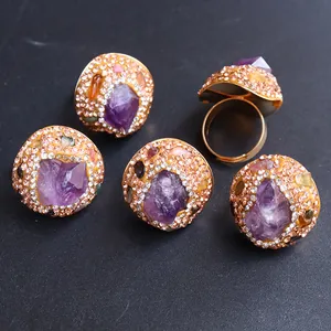 Detailansicht vergoldeter Ringe mit natürlichen Amethyst-Kristallen und Pave-Strasssteinen