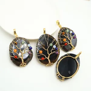 Detail of tree of life pendants with seven chakra stones on black agate stones