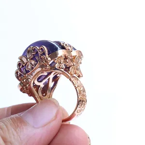 Floral amethyst crystal ring with rose gold butterfly hollow design on white background