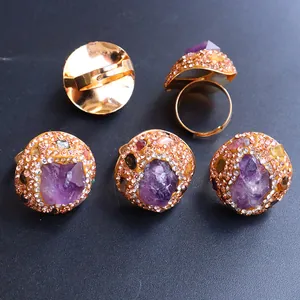 Detailansicht eines Amethyst-Natursteinrings mit strassbesetztem Goldband im Nahbereich