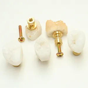 Detail of natural crystal stone drawer handle with brass base and mounting screw