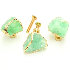 Macro view of green natural stone drawer knobs with gold brass base and screws