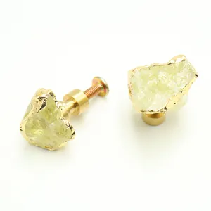 Detailed view of yellow quartz cabinet handles with gold brass base and mounting screws