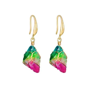 Detail of wire-wrapped earrings with rainbow gradient raw crystals and gold hooks